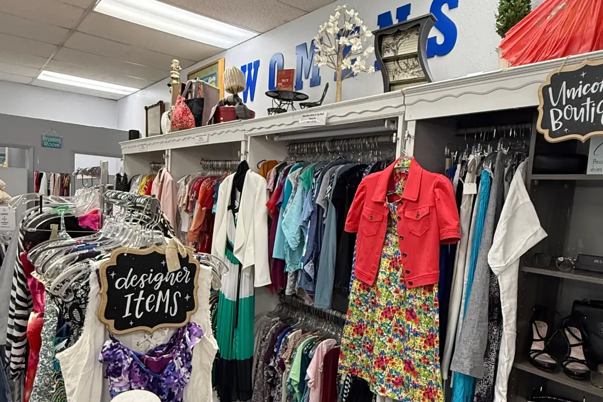 Designer clothing and shoes displayed in a thrift store boutique section