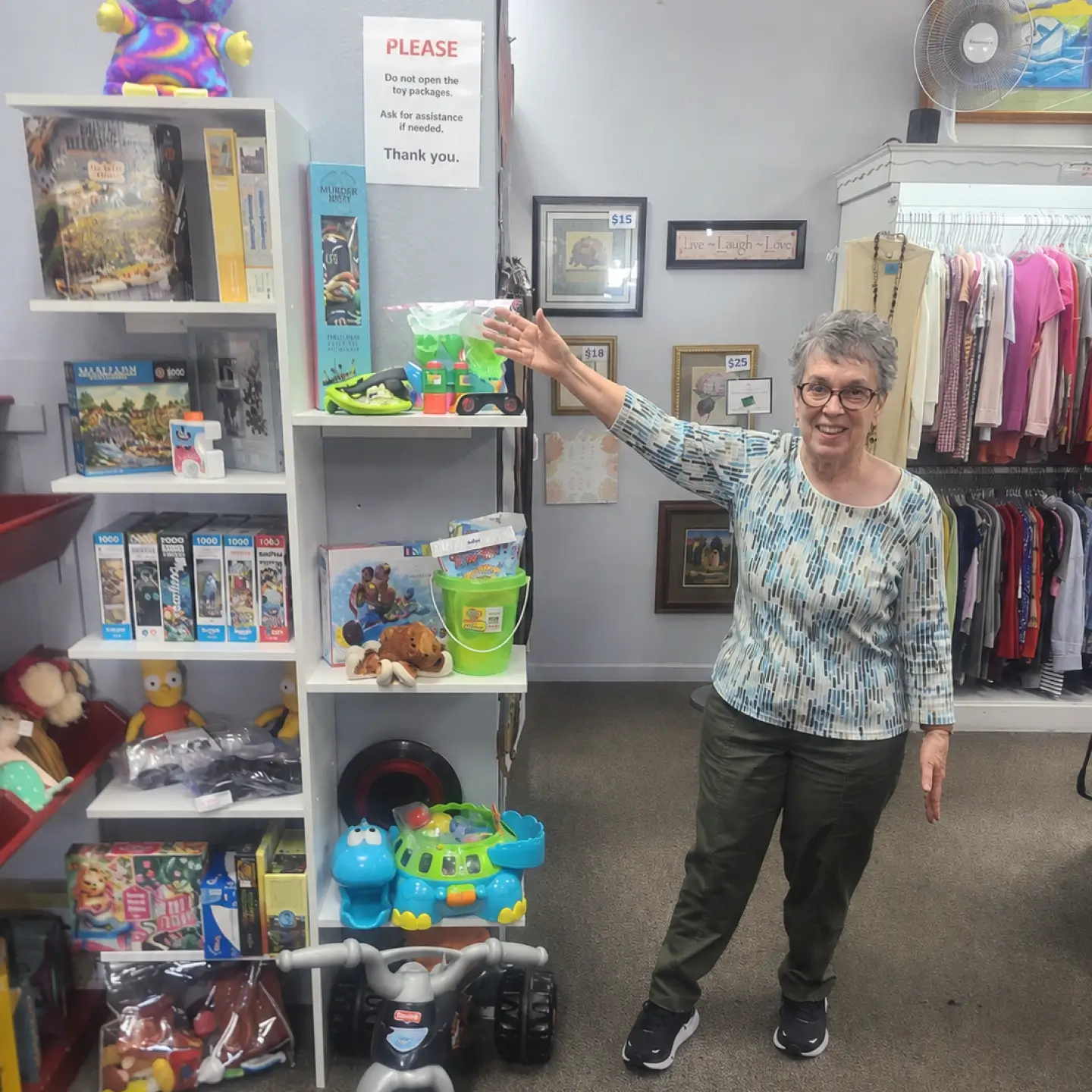Woman standing beside shelves of toys and household items in a thrift store