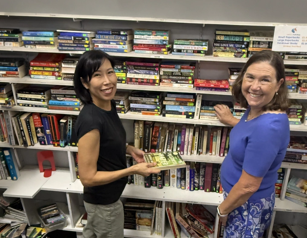 Two women browsing books on a shelf